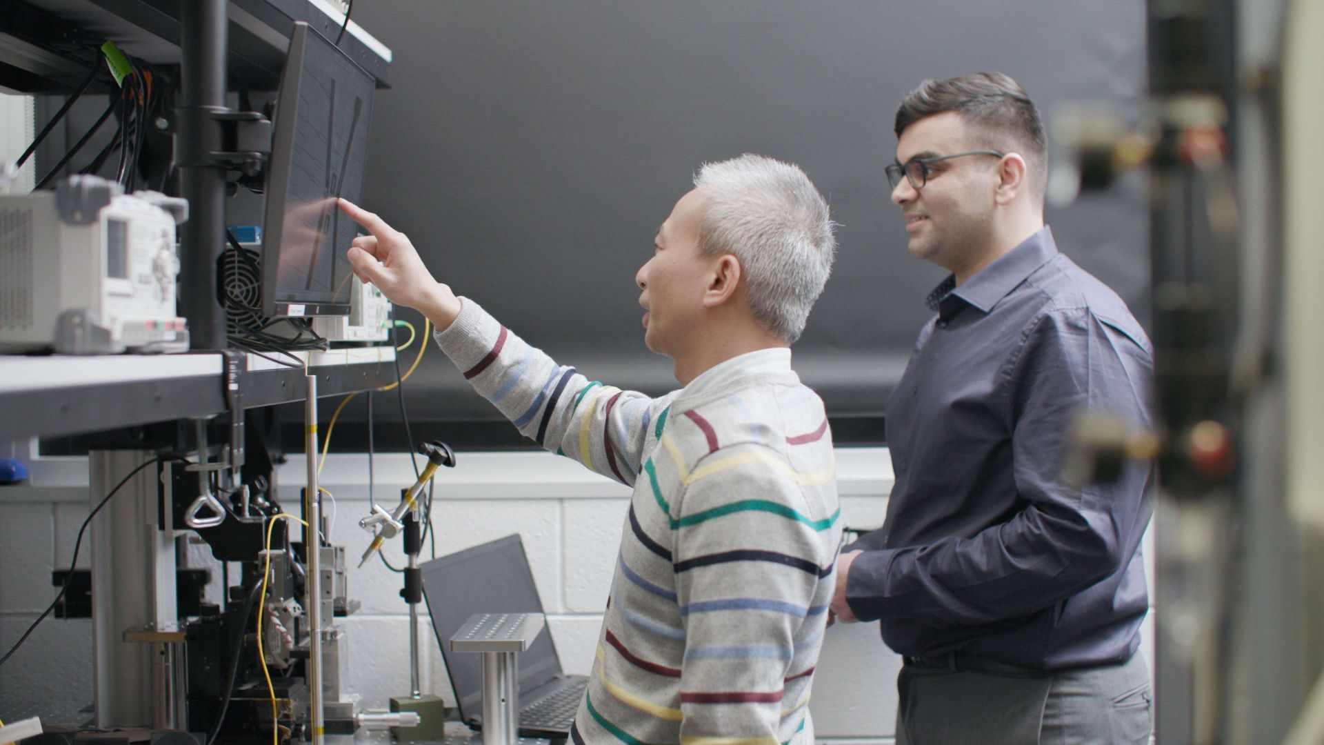 Associate Professor Thach Nguyen showing PhD researcher Aditya Vashi the design of a light-powered chip at RMIT's Integrated Photonics and Applications Centre (InPAC).